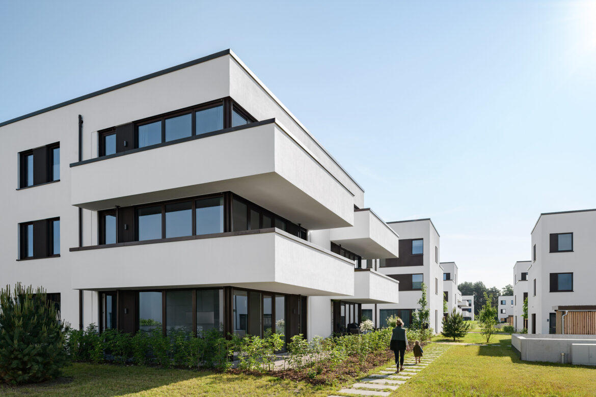 Architectural detail of a contemporary residential building with balconies, large windows, and contrasting finishes